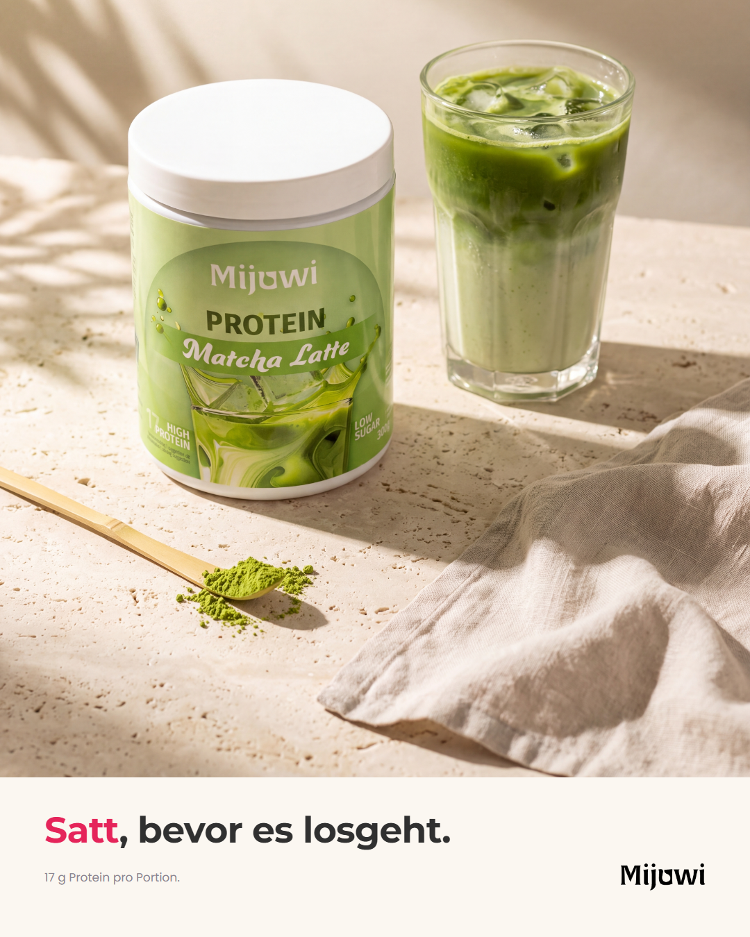 Dose und Glas Matcha Latte auf heller Steinfläche im Morgenlicht